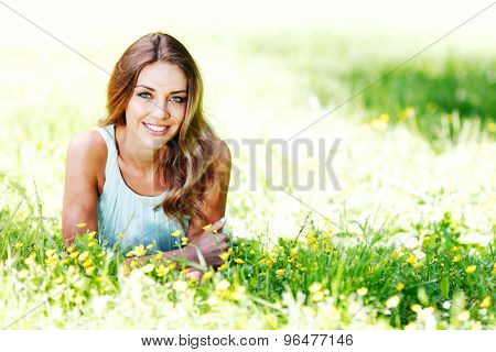beautiful young woman in blue dress lying on grass