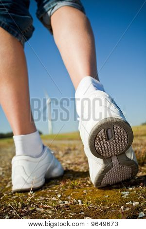Samice Hiker chůzi na cestě - větrné turbíny v pozadí