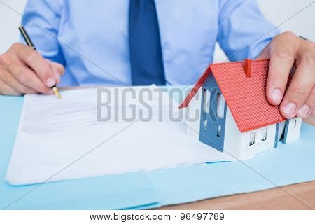 Businessman reading and writing a contrat before signing it in the office