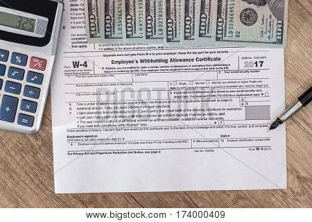 w4 tax form with money and pen.