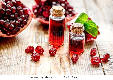 sliced pomegranate and extract in glass on wooden background close up