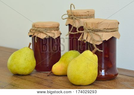Pears and glass jars of jam on the table.