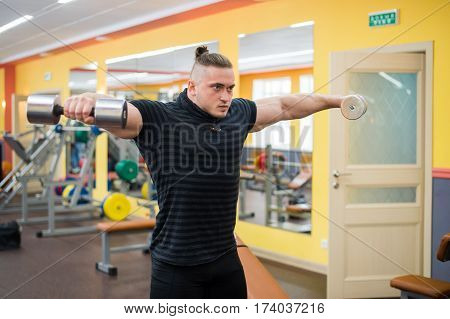 Young handsome athlete in old rusty gym.