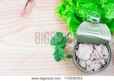 canned tuna on wood table / Canned albacore pink meat tuna packed in water
