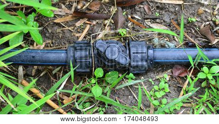 Black HDPE water piping valve in the garden