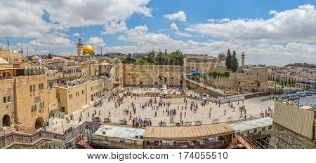 JERUSALEM, ISRAEL - MAY 23, 2016: Panoramic view of the prayers making their wishes and prays at the Western Wall, located in the Old City at the foot of the western side of the Temple Mount.