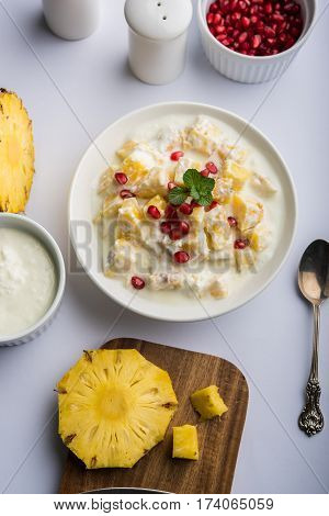 ananas or anaanaas or pineapple raita, chopped pieces of pineapple mixed with sweet curd and garnished with pomegranate and mint, favourite side dish or starter food in India