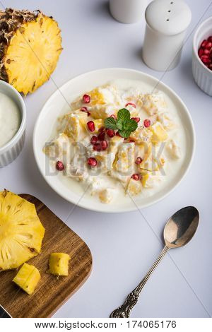 ananas or anaanaas or pineapple raita, chopped pieces of pineapple mixed with sweet curd and garnished with pomegranate and mint, favourite side dish or starter food in India