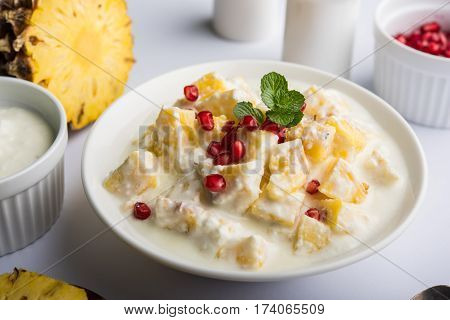 ananas or anaanaas or pineapple raita, chopped pieces of pineapple mixed with sweet curd and garnished with pomegranate and mint, favourite side dish or starter food in India