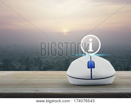 Information sign icon with wireless computer mouse on wooden table over modern city tower at sunset vintage style Customer support concept
