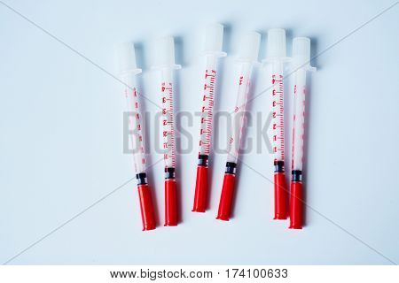 Top view of plastic insulin syringes with covers isolated on white background