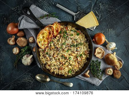 Mushroom Risotto in iron pan with herbs and parmesan cheese.