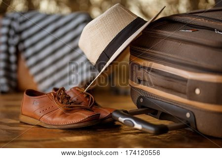 Male shoes and hat on suitcase. Travel concept.