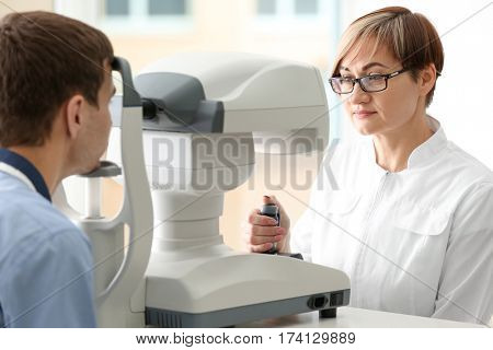 Ophthalmologist measuring intraocular pressure of young man in clinic