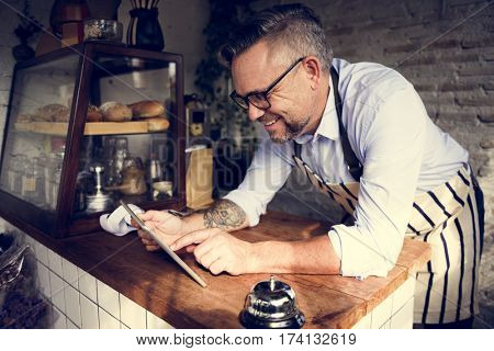 Man using devices for online business order at bakehouse