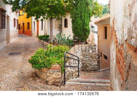 Scenic alley with traditional Spanish white houses in the old town area of Albaicin, Granada, Andalusia, Spain