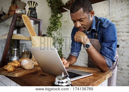 Man using devices for online business order at bakehouse