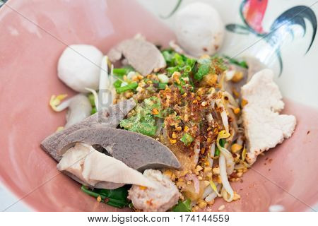 Thai Fusion Food dry noodle with pork in ceramic bowl with Thai style spice