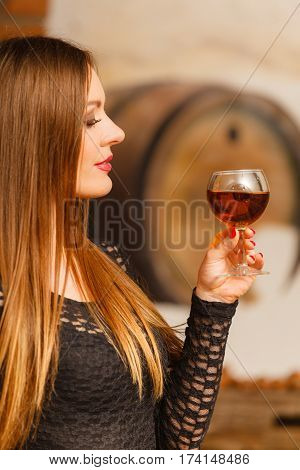 Woman Tasting Wine In Rural Cottage Interior