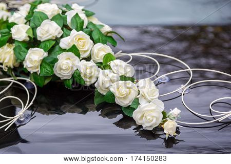Beautiful flowers decoration on wedding car bonnet. White flowers on the hood of car