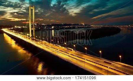 Automobile and railroad bridge in Kiev, the capital of Ukraine. Bridge at sunset across the Dnieper River. Kiev bridge against the backdrop of a beautiful sunset in Kiev. Bridge in evening sunshine.
