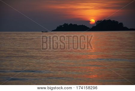 Fishing men at boat during asian sunset