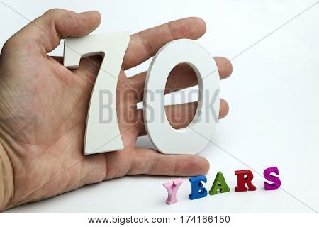Hand holding number seventy on white background.