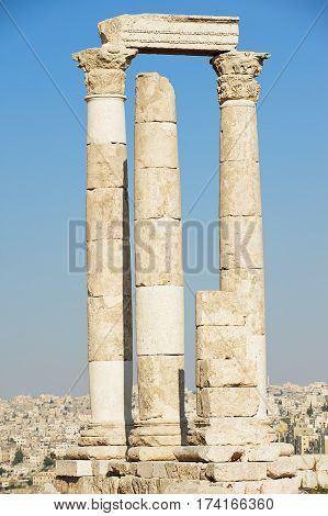 View to the ancient stone columns at the Citadel of Amman with the Amman city at the background in Amman, Jordan.