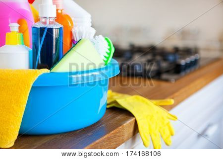 Basket With Cleaning Items On Blurry Background White Citchen. Cleaning Concept.