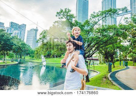 Father And Son Travelers In Malaysia Against A Background Towers Patronas Twins. Traveling With Chil