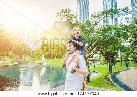 Father And Son Travelers In Malaysia Against A Background Towers Patronas Twins. Traveling With Chil