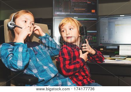 Adorable toddler boy and his sister spend the day at their parent's work in a trading room at the bank