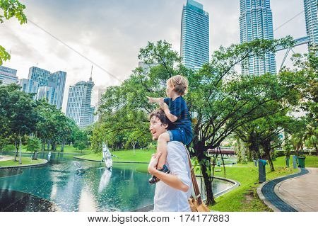 Father And Son Travelers In Malaysia Against A Background Towers Patronas Twins. Traveling With Chil