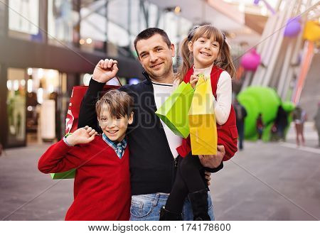 Happy father with children have a successful day of shopping