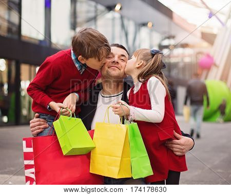 Happy father with children have a successful day of shopping