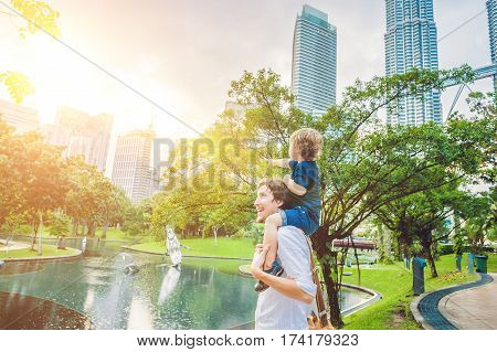 Father And Son Travelers In Malaysia Against A Background Towers Patronas Twins. Traveling With Chil