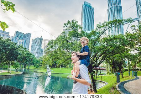 Father And Son Travelers In Malaysia Against A Background Towers Patronas Twins. Traveling With Chil