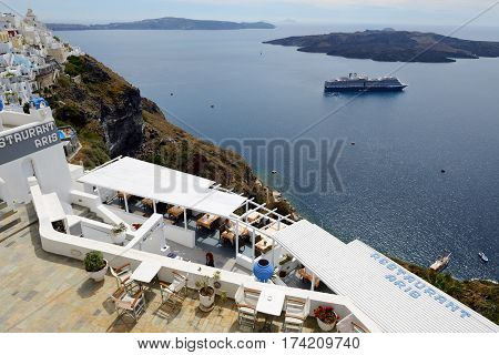 FIRA GREECE - MAY 17: The view on Fira town and tourists enjoying their vacation on May 17 2014 in Fira Greece. Up to 16 mln tourists is expected to visit Greece in year 2014.