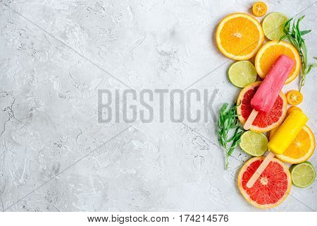 homemade citrus popsicles with fresh fruit slices on stone table background top view mockup