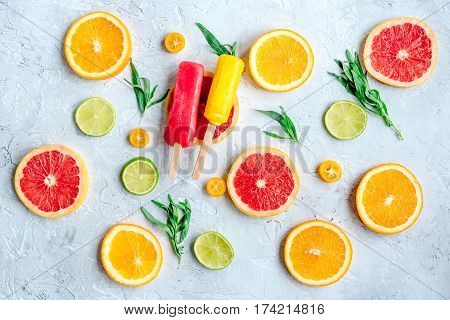 homemade ice-cream with sliced oranges and lime on stone table background top view pattern
