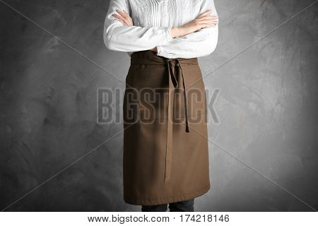 Woman wearing apron on color background