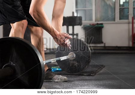 Weightlifter Hand Applying Talc Powder Before Doing Exercise With Barbell In Gym