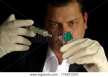 Young Businessman Gives A Financial Injection To Turkmenistani Flag Isolated On Black Background