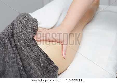 Deep tissue massage on a woman's hip gluteus muscles