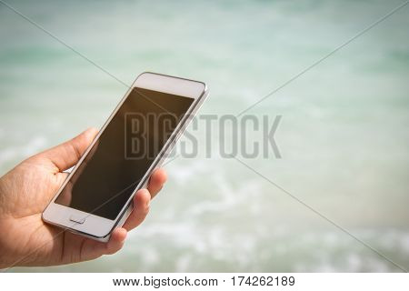 taking picture by smart phone selfie on blurred beautiful at beach background Vacation concept