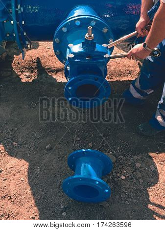 Worker Hands Screwing Gate Valve With Nuts On Piping.