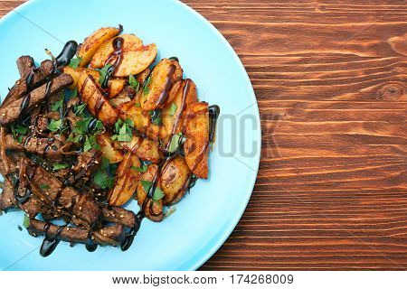 Homemade Slow Cooked Beef with Potatoes on wooden background