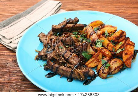 Homemade Slow Cooked Beef with Potatoes on wooden background