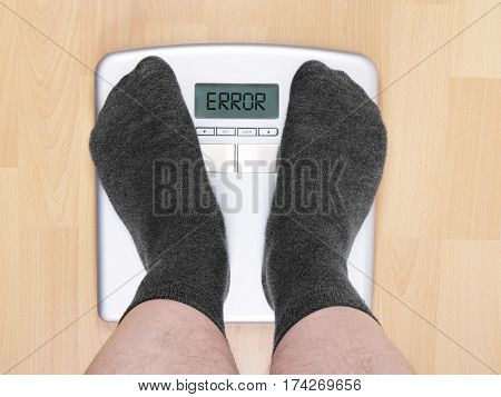 overweight man on personal scales, display shows error
