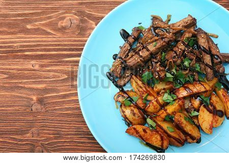 Homemade Slow Cooked Beef with Potatoes on wooden background